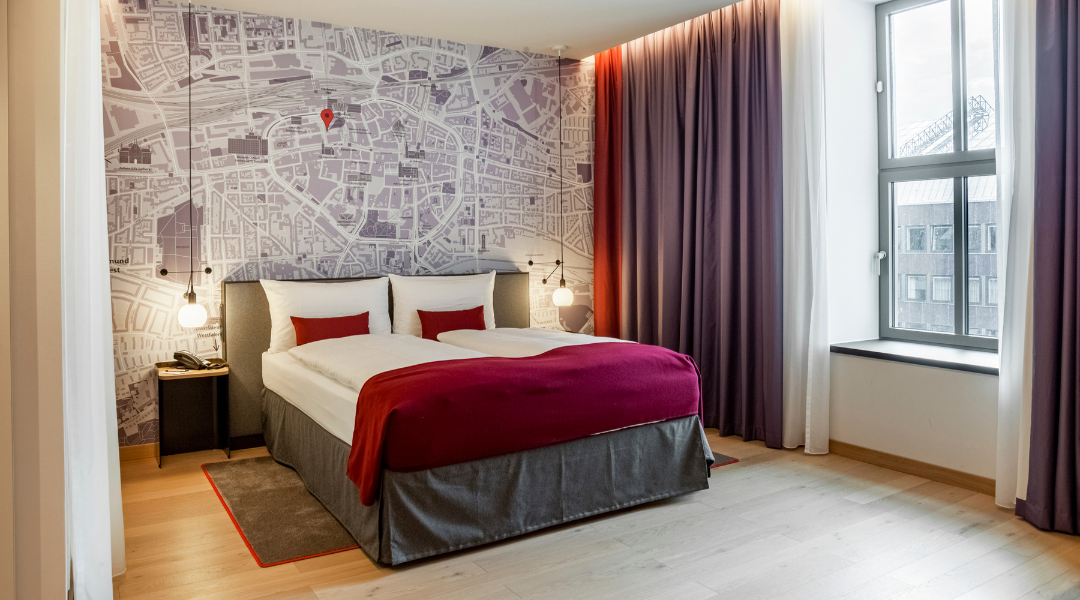 Hotel Deal Intercity Eine Aufnahme eines Hotelzimmers auf dem ein Doppelbett zu sehen ist.